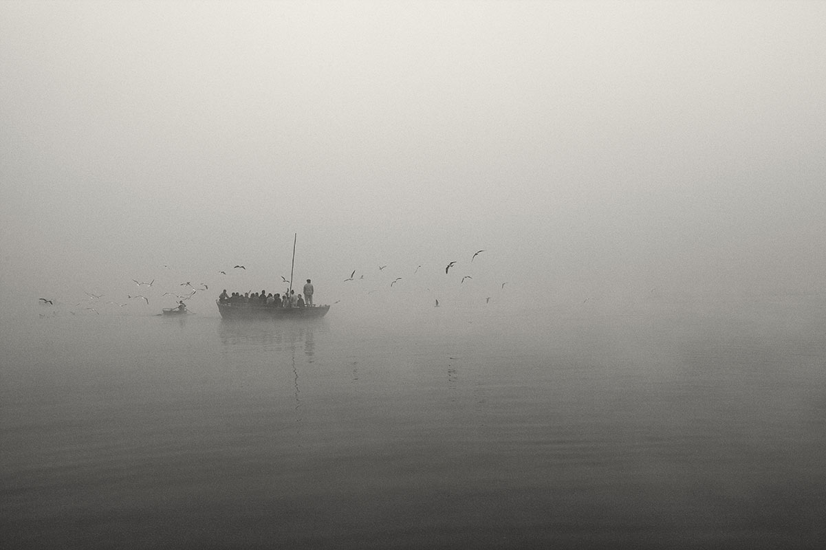 Boat full of Hindu worshippers in morning mist