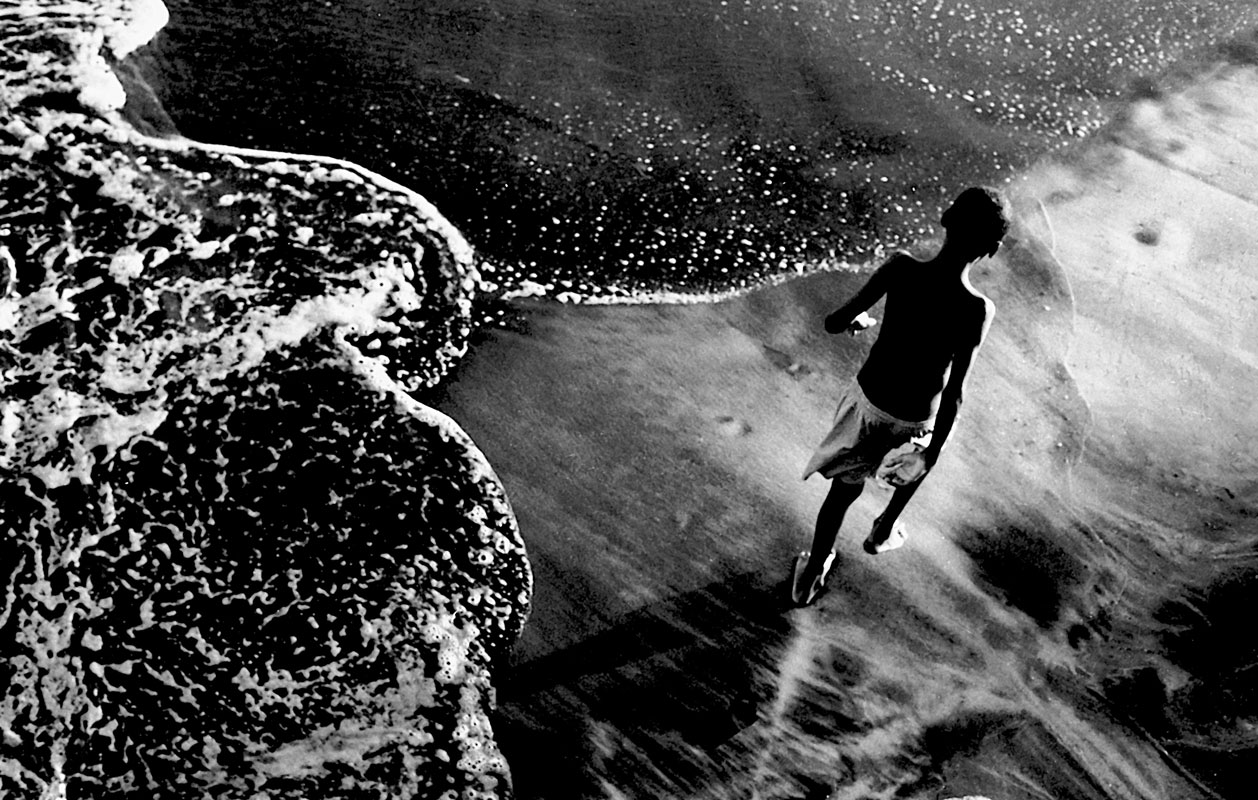 Black favela child plays in Bahian surf