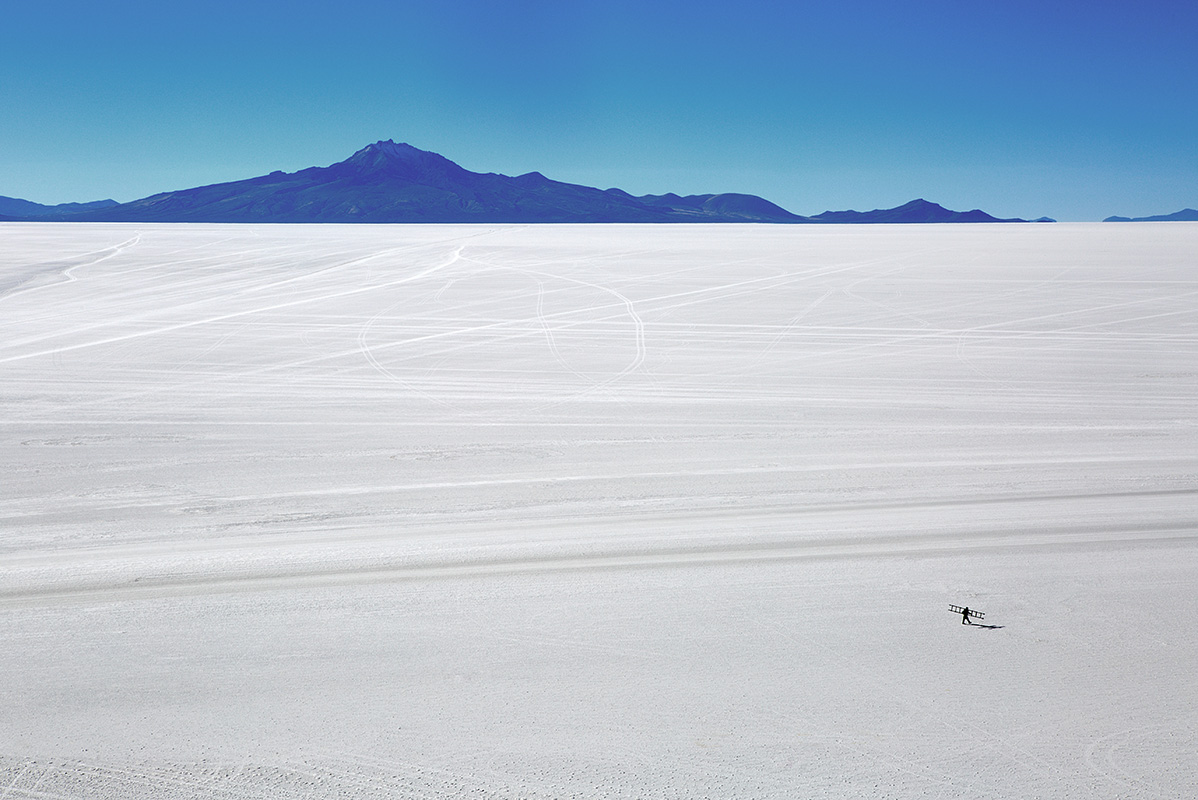 Solitary figure with ladder crosses the Bolivian salt flats