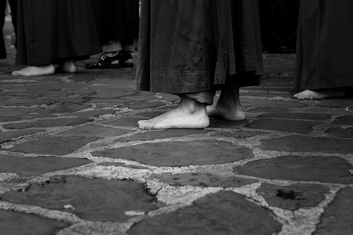 Barefooted devotee walks cobbled streets