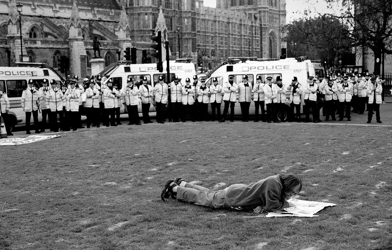 Police intimidate man reading newspaper at a political demonstration in London